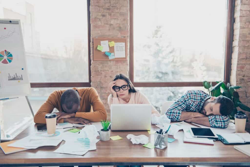 Exhausted office workers asleep at their desks