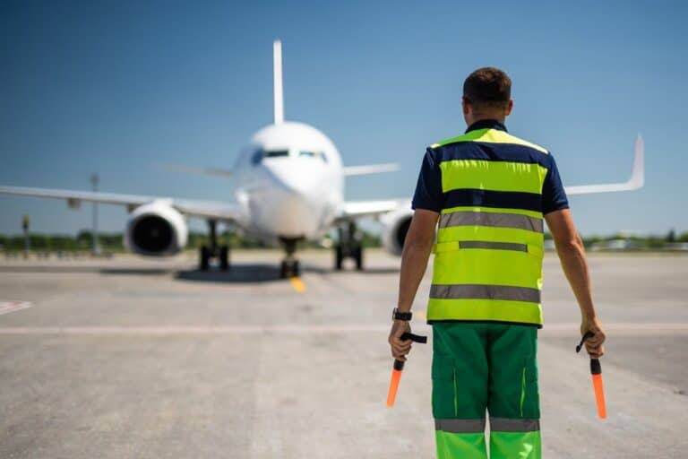 Airport ground crew marshalling an aircraft