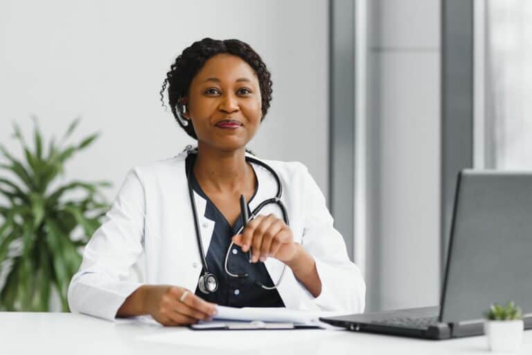 GP at her desk with a stethoscope