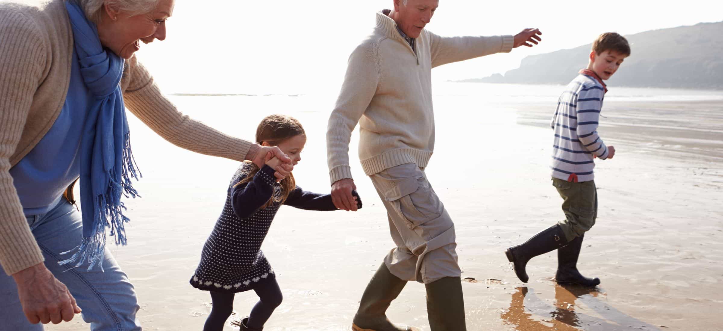 Grandparents and children playing on the beach